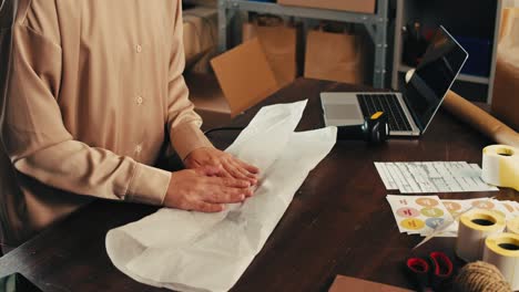 woman packing an order at a desk