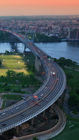 nice cozy area between two bridges in new york. city switching on evening lights. enormous cityscape under pink sun at sunset. vertical video