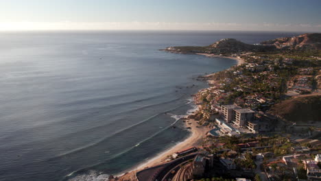 high aerial shot of waves crashing on beaches of los cabos mexico