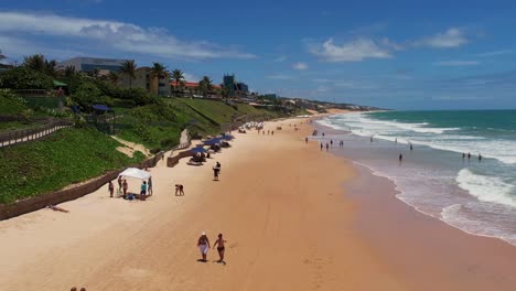 Sobrevuelo-Hermosa-Playa-Con-Agua-Turquesa-Gente-Caminando-Sobre-La-Arena,-Natal