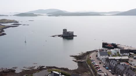 Wide-drone-shot-of-Kisimul-castle-and-the-town-of-Castlebay-on-the-Isle-of-Barra-in-the-Outer-Hebrides-of-Scotland