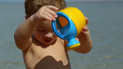 little boy having fun with toy waterpot