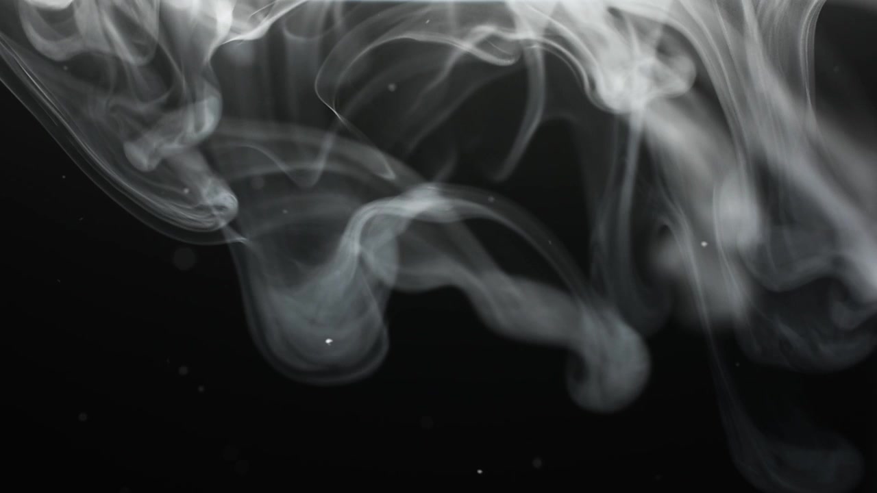 Fumo e particelle su sfondo nero.