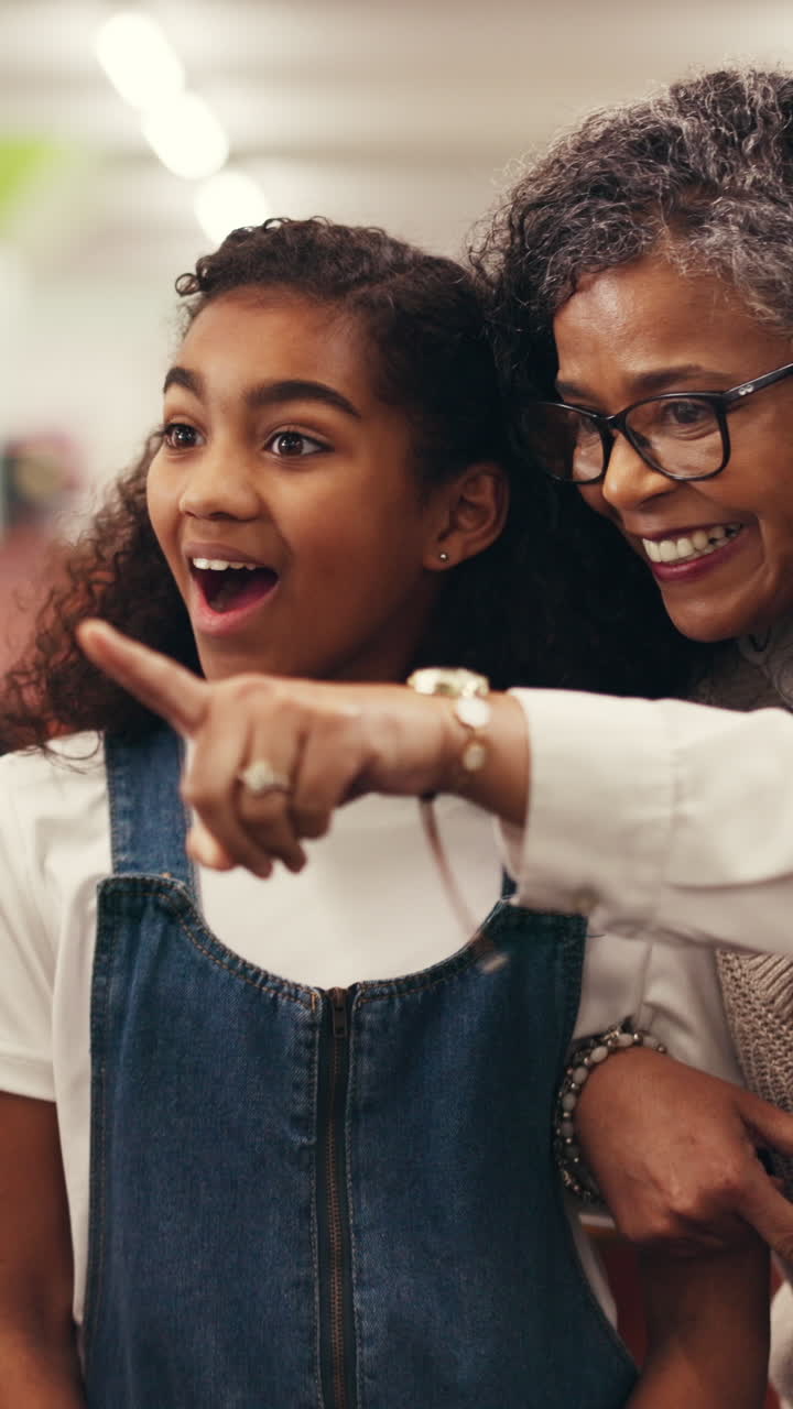 Menina e avó sorrindo e apontando animadamente