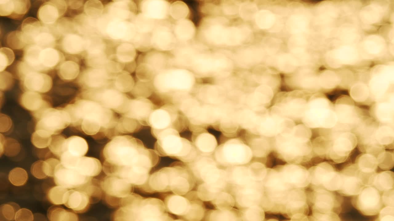 Bokeh af solnedgangslys reflekteret på havets bølger (sløret baggrund)