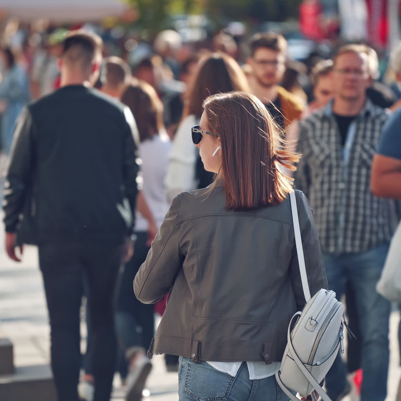 Busy city street. People walking along and back the street in warm sunny day. Crowd of people in a big city.