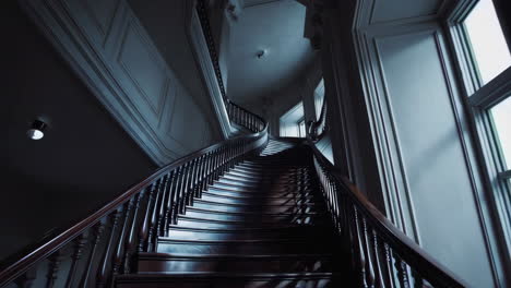 grand curved staircase in a dimly lit historic building