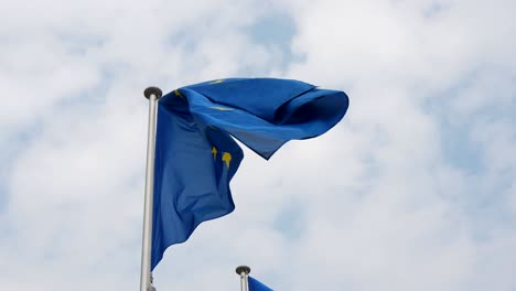 magnífica vista de una bandera de la unión europea con un fondo azul y un círculo de estrellas en bruselas en un día soleado de primavera en cámara lenta.