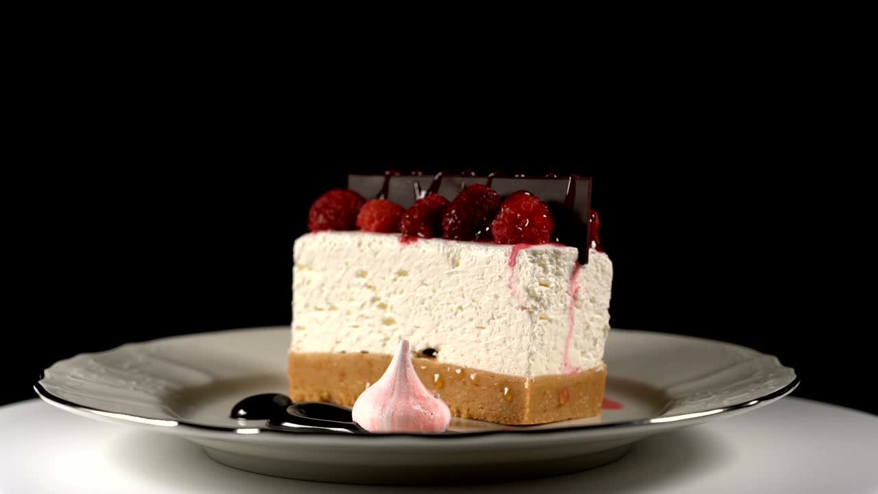 el pastel de queso gira en la mesa giratoria sobre un fondo negro