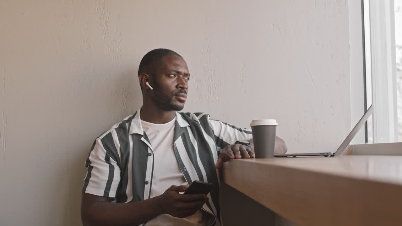 African-American Man Listening to Music in Cafe