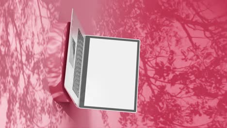 Laptop-with-blank-screen-on-a-red-background-with-floral-shadows