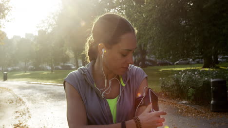 runner woman running in park exercising outdoors fitness tracker wearable technology