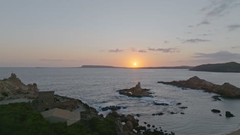 Ein-Sonnenuntergang-über-Cala-Pregonda-Mit-Sanften-Wellen,-Die-Ans-Ufer-Rollen