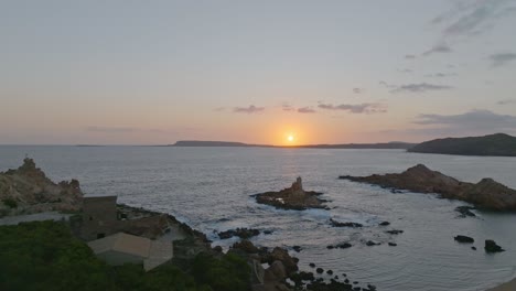 a sunset over cala pregonda with gentle wavelets rolling into shore
