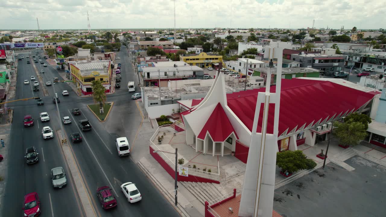 Aerial of church San P&iacute;o X and busy traffic road at Reynosa, Tamaulipas, video sequence promoting religious and spirituality concept