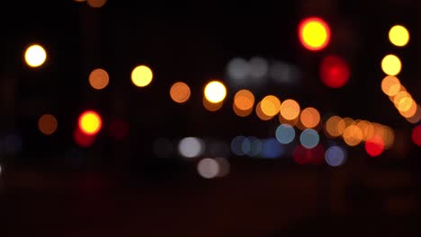 el colorido bokeh redondo brilla de las luces de los coches en el atasco de tráfico en la calle de la ciudad. hermoso bokeh brillante en el fondo oscuro borroso por la noche. concepto abstracto. refleja el estilo de vida solitario de la capital.