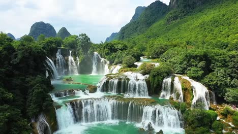 a breathtaking overhead shot of cascading waterfalls hidden within lush jungle terrain, where crystal-clear streams flow into vibrant pools beneath thick forest canopy.