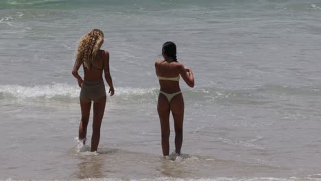 two women playing and splashing in ocean waves