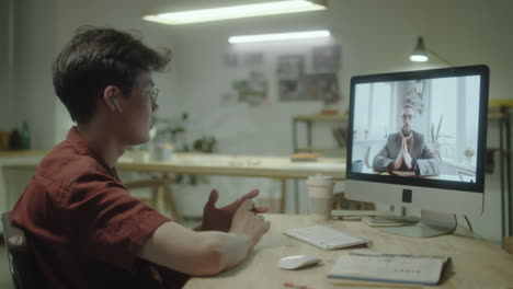 man engaged in a video call on his desktop computer