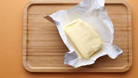 slice of a butter on a paper on table