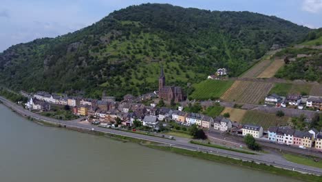 Iglesia-Medieval-Y-Coloridas-Casas-Junto-Al-Río-En-La-Ladera-De-La-Ciudad-Alemana-De-Lorchhausen