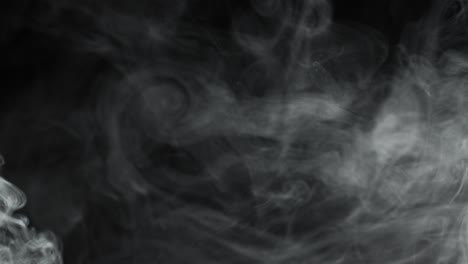smoke on black background. gray smoke guickly pours in portions.