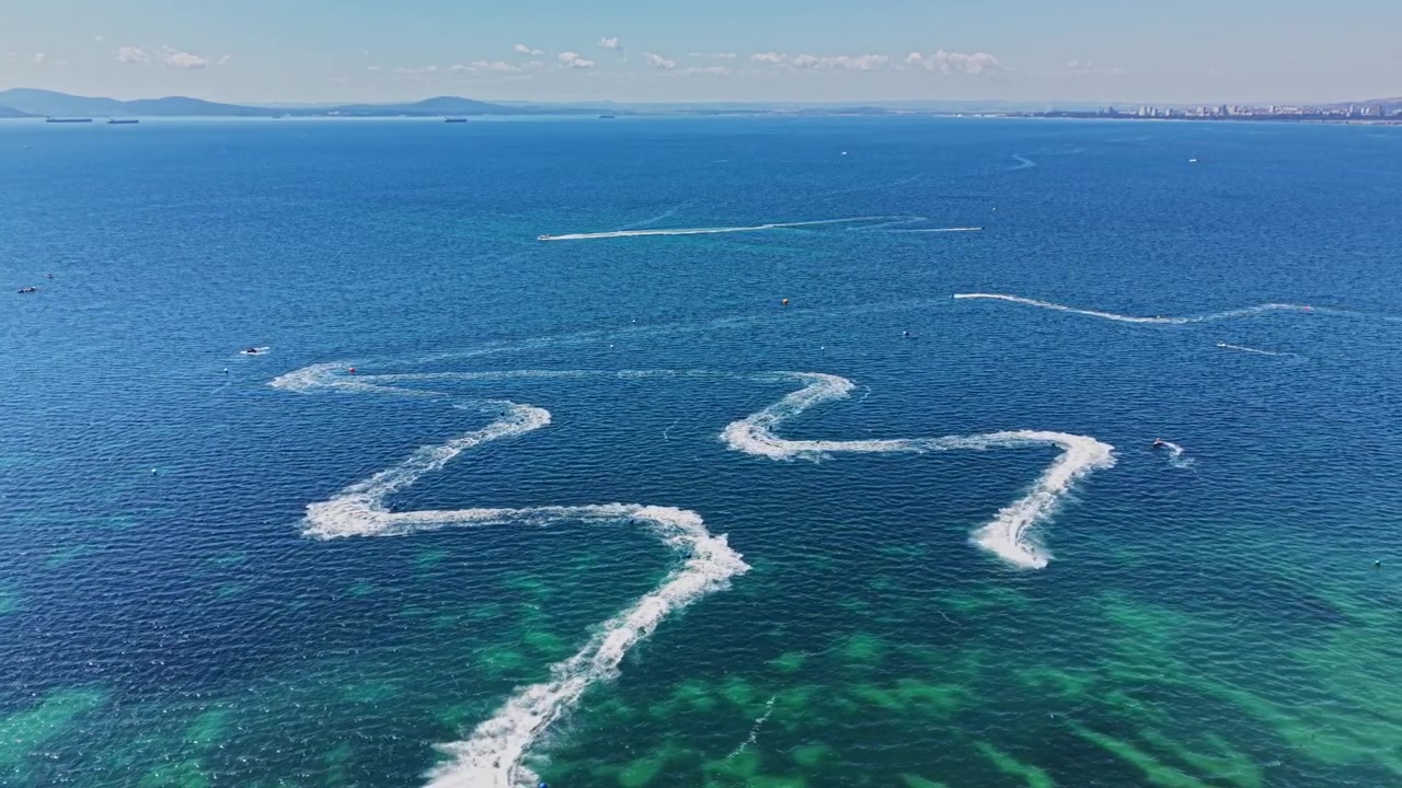 Barco cria ondas em água límpida no oceano durante o dia
