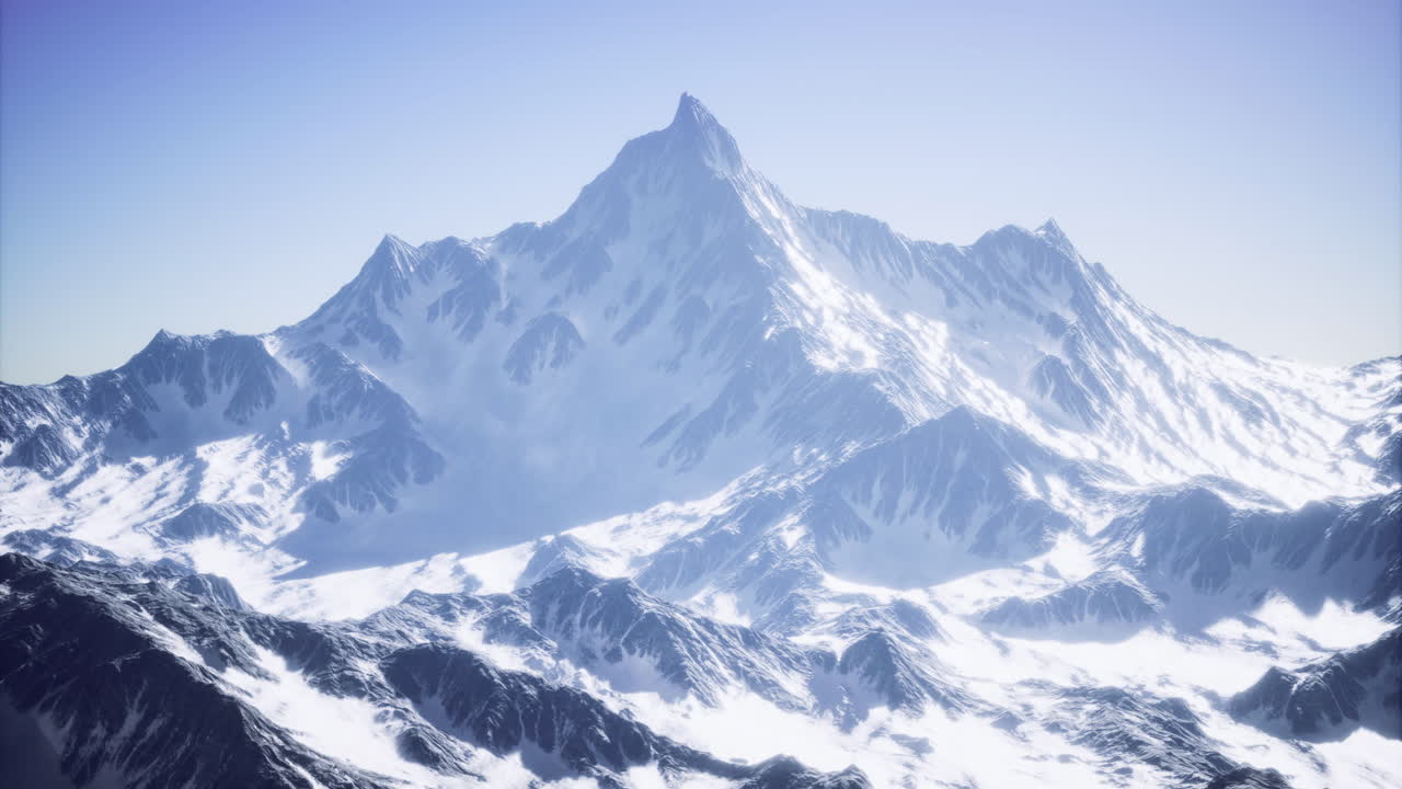 Majestic snow capped peak rises under a clear blue sky during daylight hours