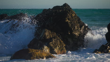 olas golpeando una roca en cámara lenta