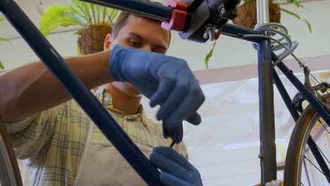 Man-repairing-bicycle-in-workshop-4k