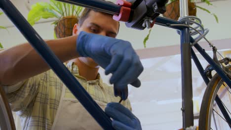 hombre reparando una bicicleta en el taller 4k