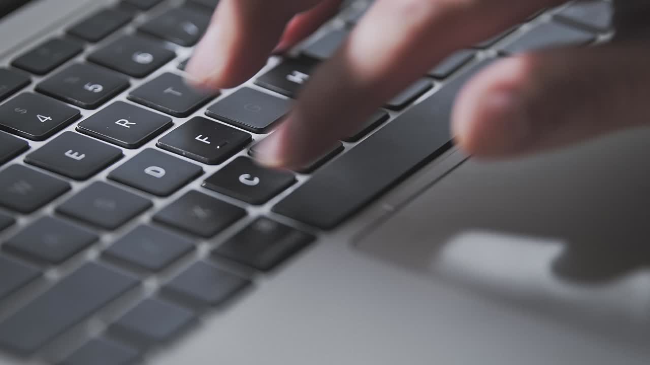 un primer plano de un joven con la mano ocupada escribiendo.