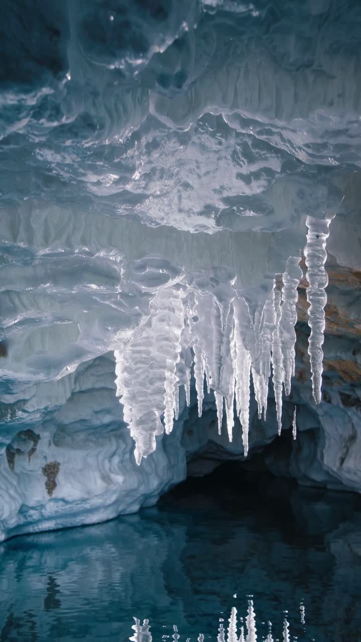 A mesmerizing video of icicles hanging from a cave ceiling, captured from a low angle