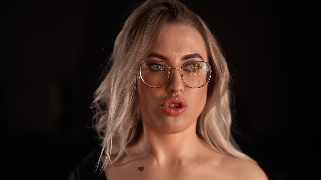 Ritratto di una ragazza attraente con gli occhiali che guarda l'obiettivo.