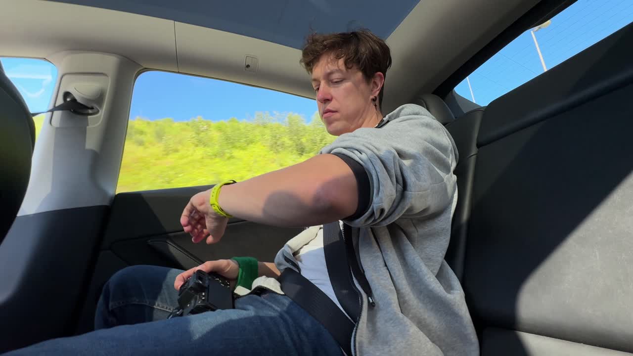 Person looking at watch while traveling in a Tesla car
