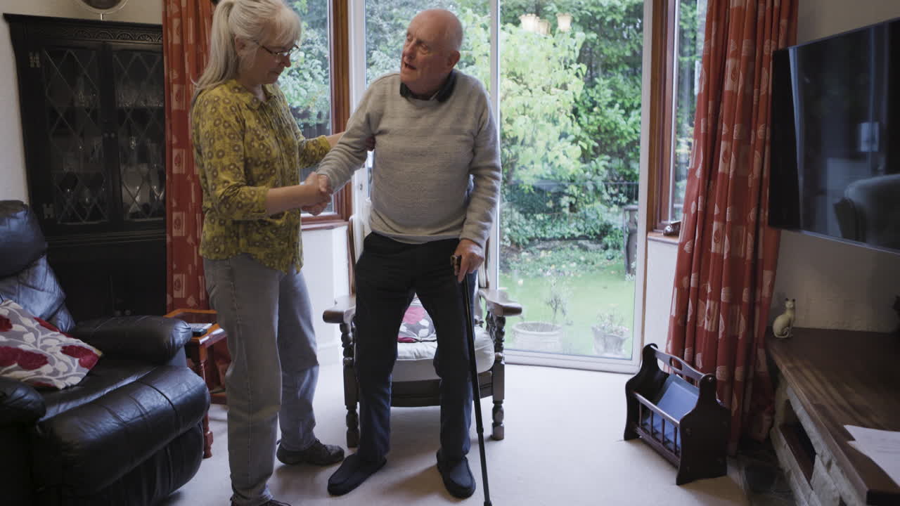 Elderly man receiving assistance from a caregiver at home