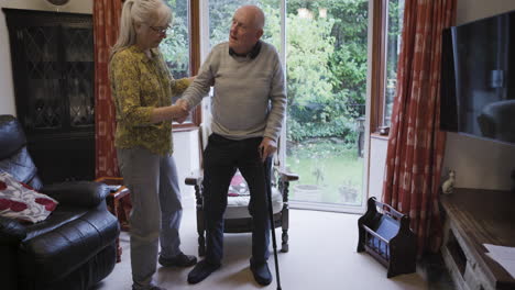 elderly man receiving assistance from a caregiver at home
