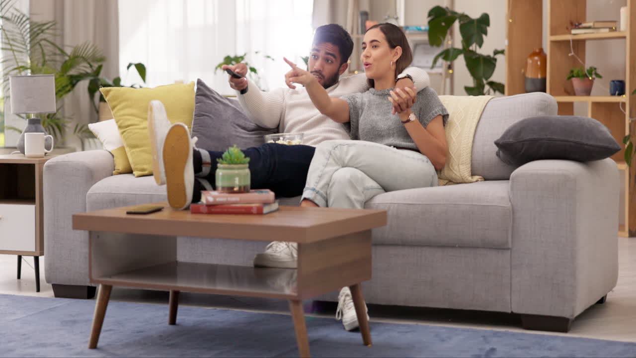 feliz, relajarse y ver la televisión con la pareja en el sofá