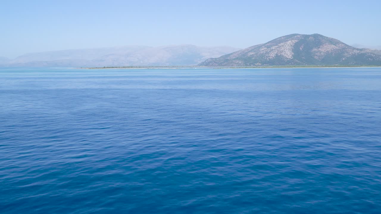 Shot of Sea Horizon with blue ocean water and mountain background