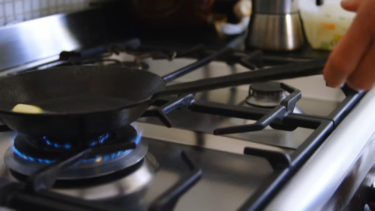 Man holding a pan on gas stove hob 4k