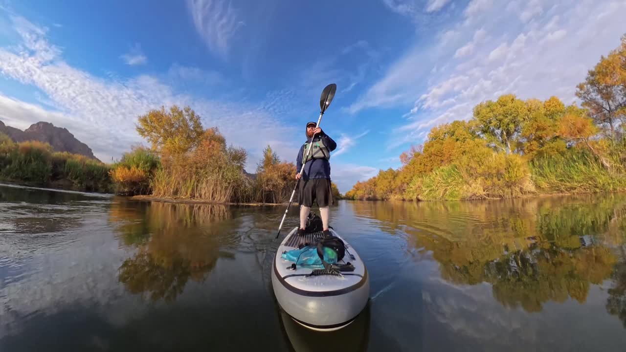 Paddler standing in a low angle wide shot of them paddling through the Lower salt