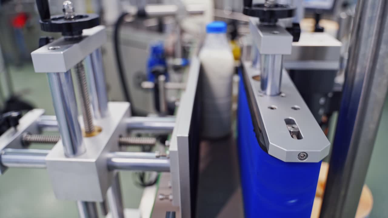 Modern equipment on a dairy factory. Automatic production line with milk bottles in upgraded dairy plant.