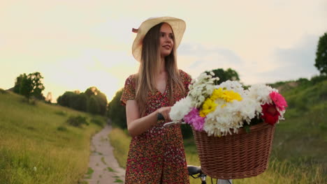 Middle-plan-girl-in-dress-goes-with-bike-and-flowers-in-the-field