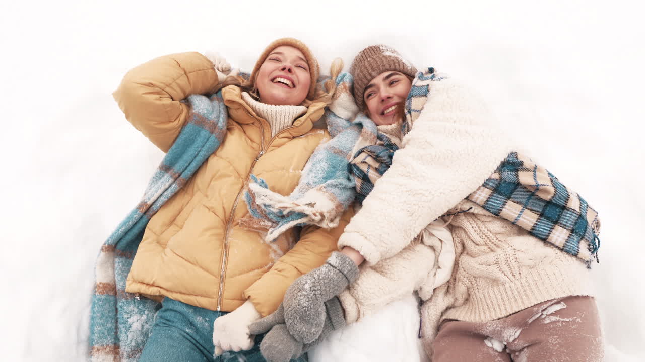 두 소녀가 눈 속에서 즐겁게 놀고 있다.