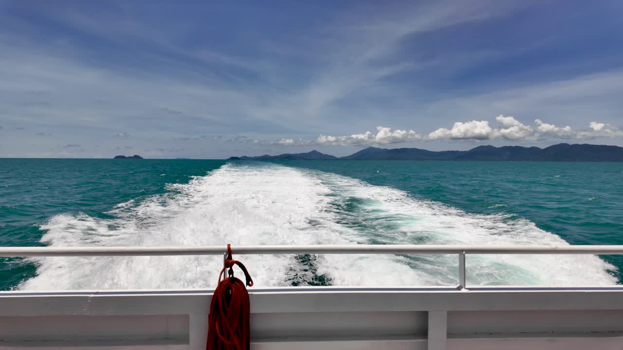 Experience a serene journey as a ferry boat slices through turquoise ocean waters, leaving a wake behind. Ideal for island hopping or exploring tropical destinations.