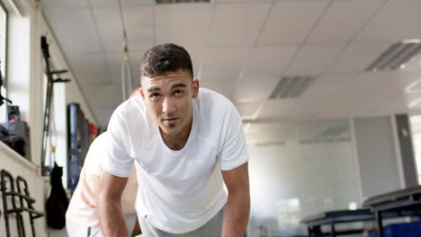 man in rehabilitation center doing push-ups with assistance from therapist