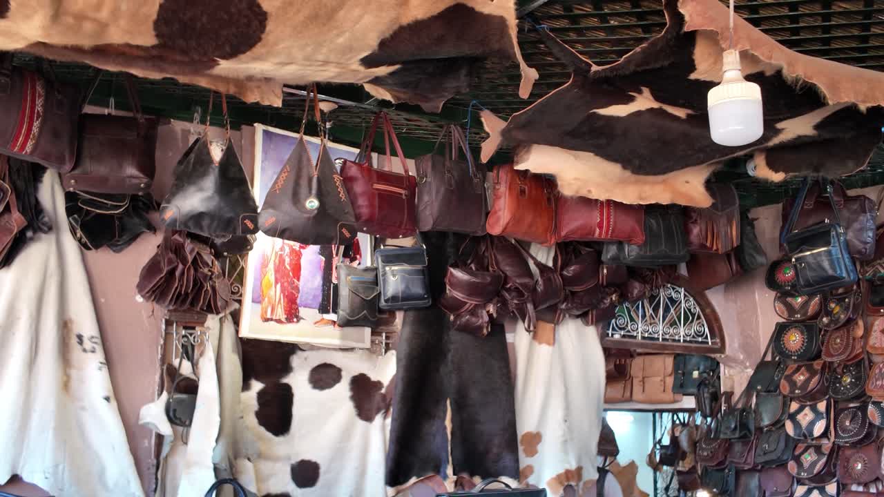 Colorful leather bags and cowhides hanging in a traditional leather shop in the Fes Medina, Chouara Tannery, Morocco