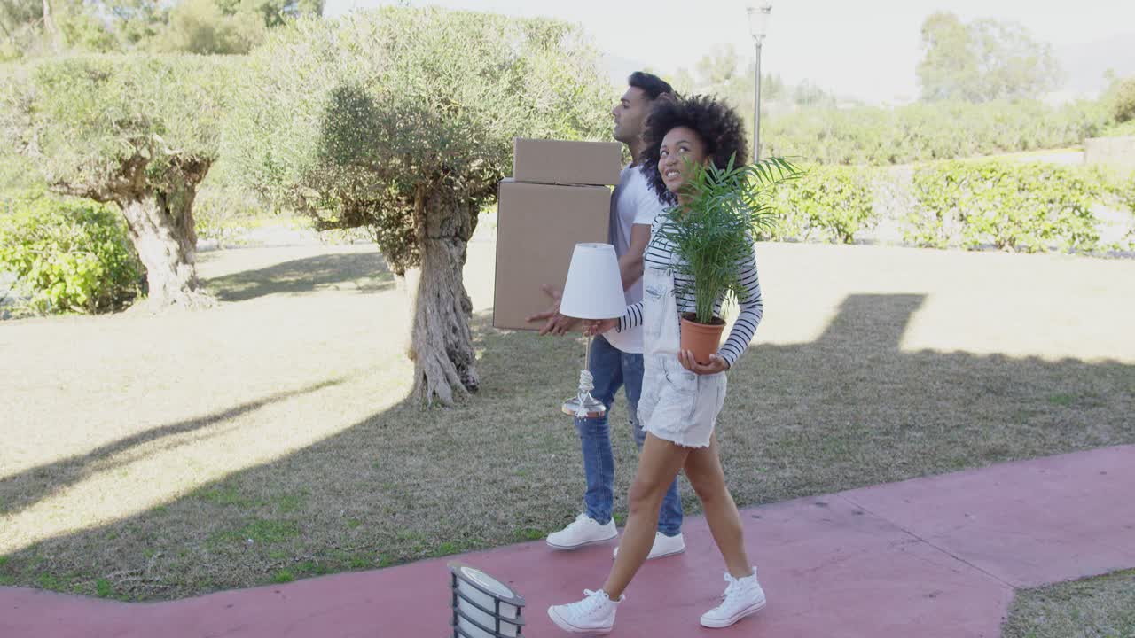 pareja joven mudanza cargando cajas