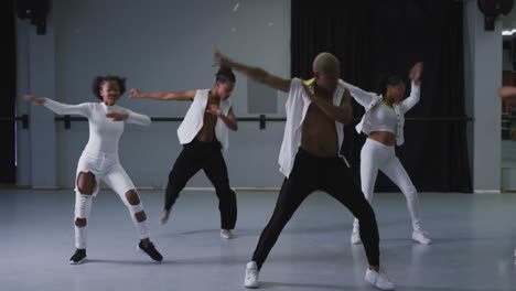 multi-ethnic group of fit male and female modern dancers practicing dance routine