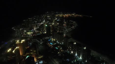 nighttime illumination of punta del este uruguay coastline, revealing vibrant cityscape glowing with urban energy under starlit caribbean sky
